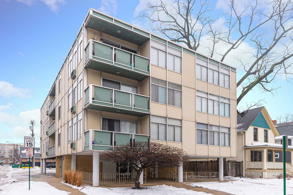 Front view of a multi-story apartment building with balconies.