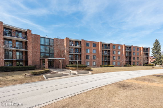 Front view of a multi-story brick apartment building with balconies.