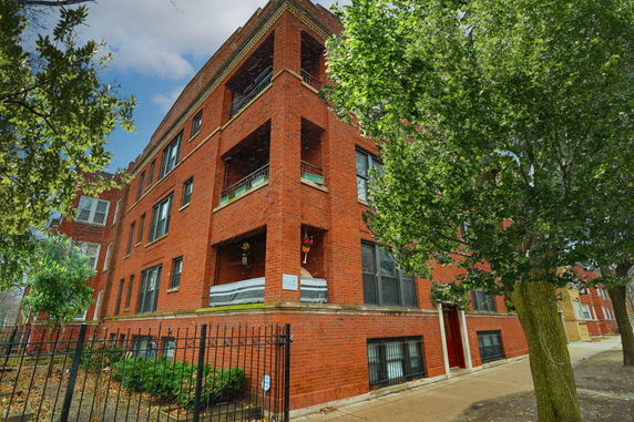 Front view of a multi-story brick apartment building.