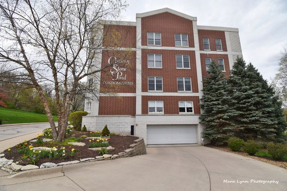 Front view of a multi-story condominium building with a garage entrance.