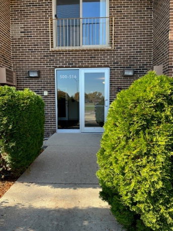Entrance view of a brick building with a glass door and window above.