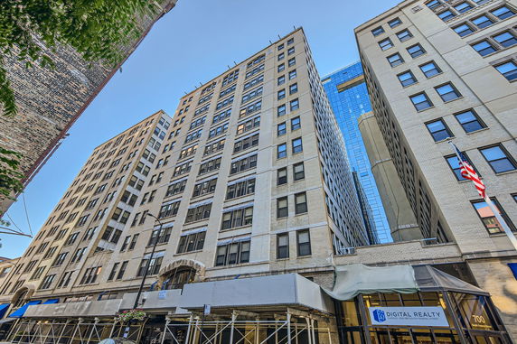 View of tall office building from street level.