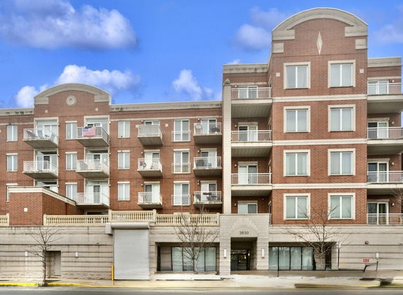 Front view of a multi-story brick building with balconies.