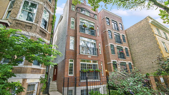 Front view of a multi-story brick building with balconies.