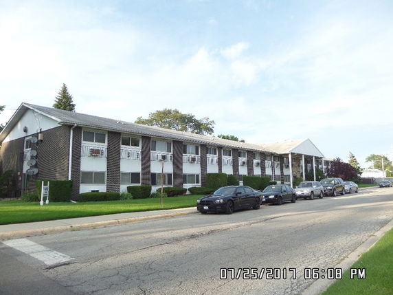 Front view of a two-story apartment building with a brick exterior.