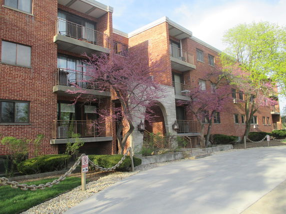 Front view of a brick apartment building with balconies.