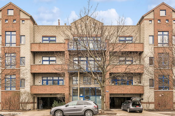 Front view of a multi-story brick and stone building with blue-framed windows.