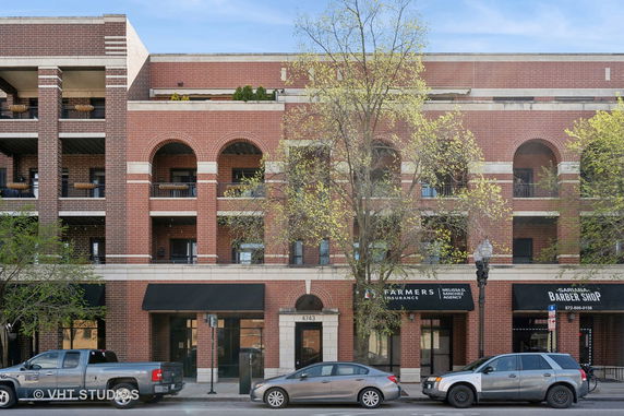 Front view of a multi-story brick building with arches and balconies.