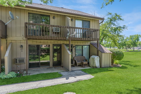 Front view of a two-story house with a balcony and patio area.