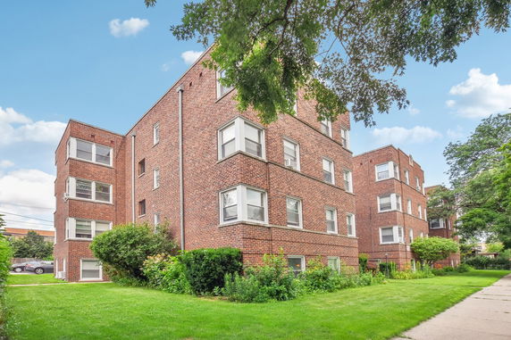 Front view of a multi-story brick building with multiple windows.