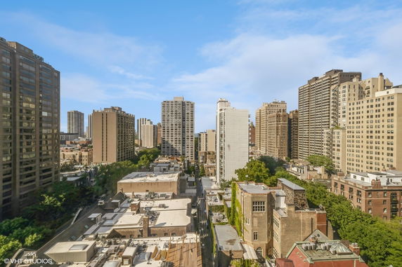 Panoramic view of a cityscape with multiple tall buildings and clear blue sky.