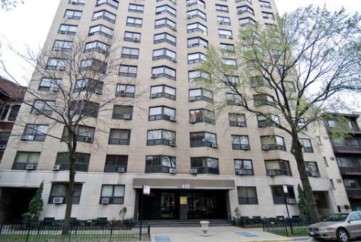 Front view of a multi-story apartment building with numerous windows.