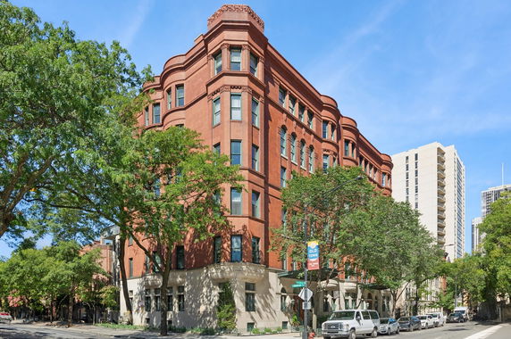 Front view of a multi-story brick building on a street corner