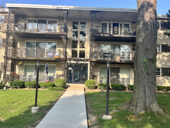Front view of a multi-story apartment building with balconies.