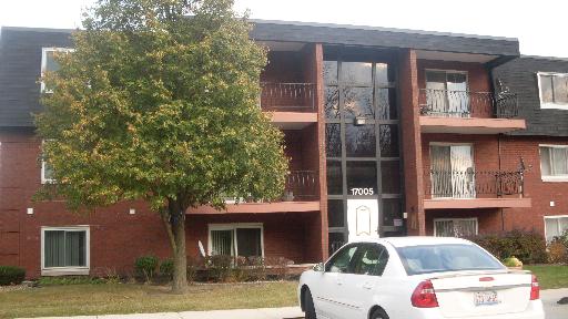 Front view of a three-story apartment building with balconies.