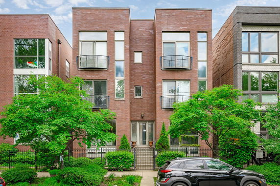 Front view of a modern three-story brick building with balconies.