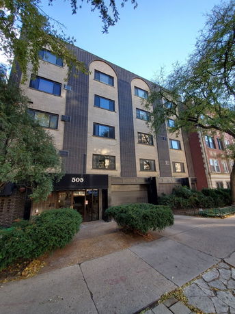 Front view of a multi-story building with a central entrance.
