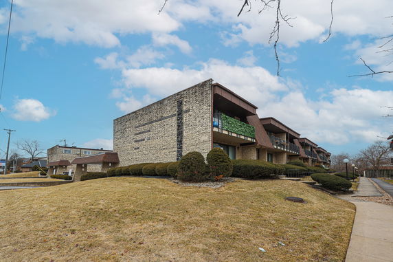 Front view of a multi-story apartment building with balconies.