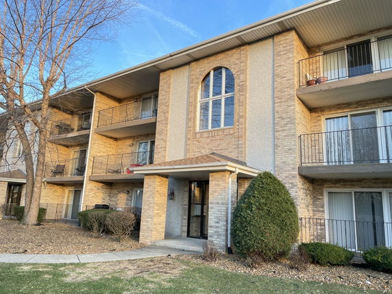 Front view of a multi-story residential building with balconies.