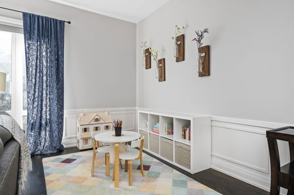 Children's play area with a small table, chairs, and shelves for storage.