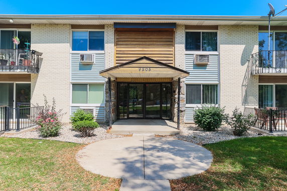 Front view of a two-story apartment building with balconies and a main entrance.