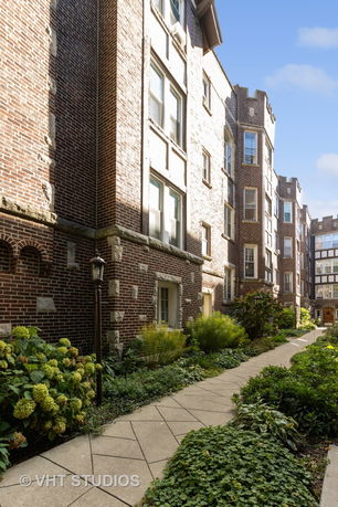 Front view of a multi-story brick apartment building with decorative stone elements.