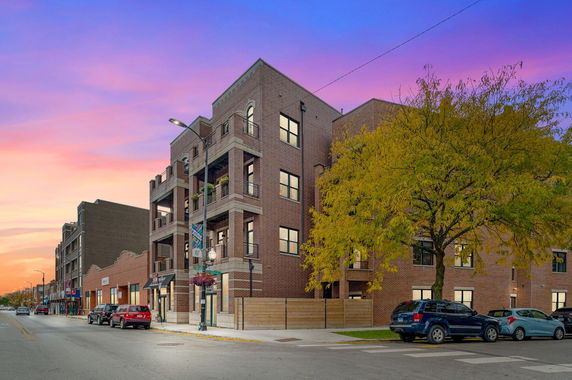 Front view of a brick multi-story building with multiple balconies.