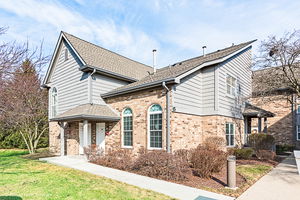Front view of a two-story house with a combination of brick and siding exterior.