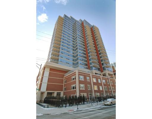 Front view of a multi-story apartment building with glass balconies.