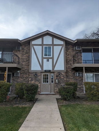 Front view of a two-story building with brick facade and a central entrance.