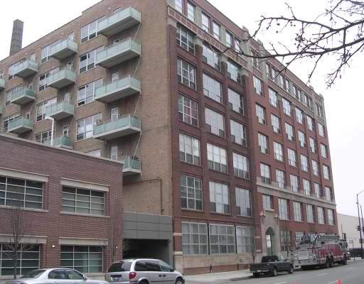 Front view of a multi-story brick apartment building with large windows and balconies.