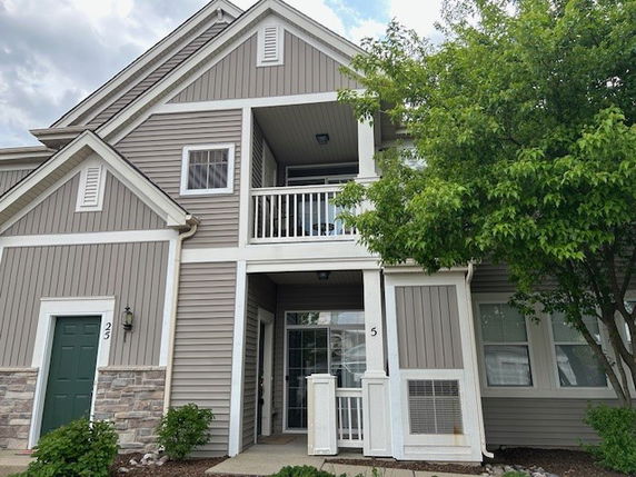 Front view of a two-story house with a balcony and siding exterior.