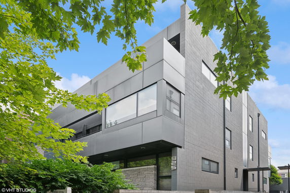Front view of a modern, multi-story building with large windows and a sleek exterior.