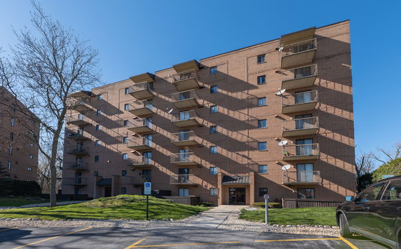 Front view of a multi-story apartment building with balconies.