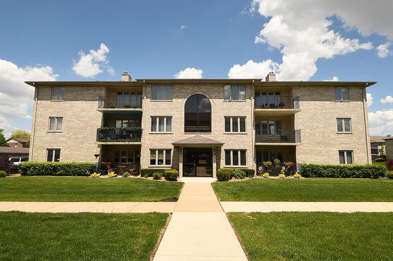Front view of a multi-story apartment building with balconies.