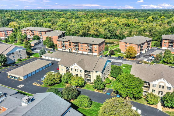 Aerial view of multiple residential buildings surrounded by greenery and roads.