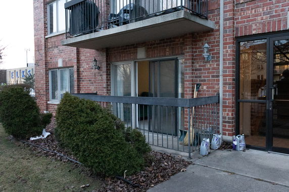 Front view of a brick apartment building with a metal balcony.