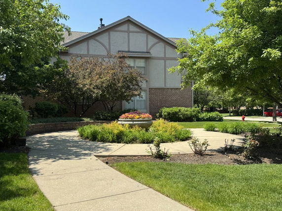 Front view of a multi-story house with a brick and stucco exterior.