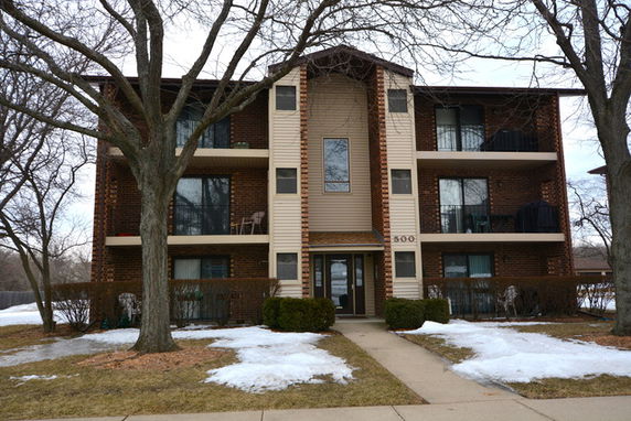 Front view of a three-story brick apartment building.