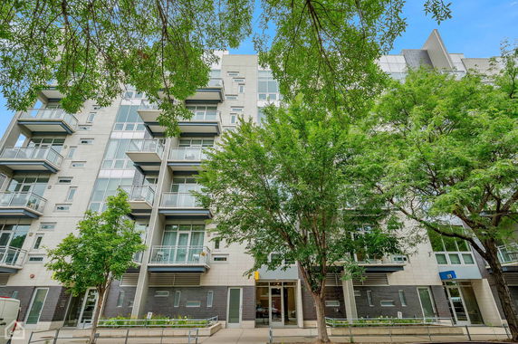 Front view of a multi-story apartment building with balconies.