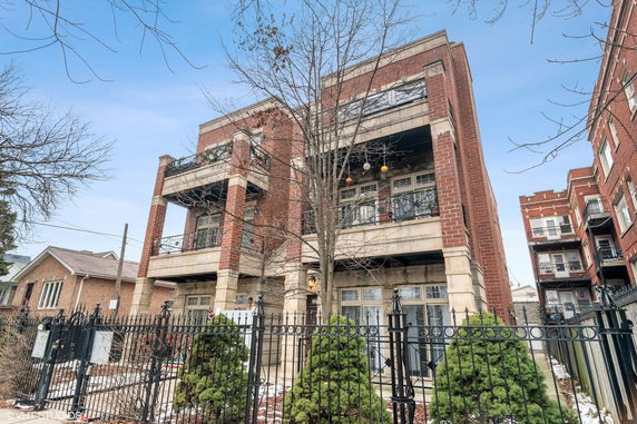 Front view of a multi-story brick building with balconies.