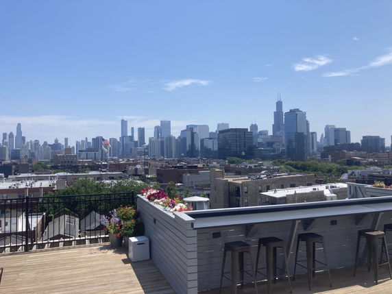 Rooftop view with a skyline in the distance and seating area.