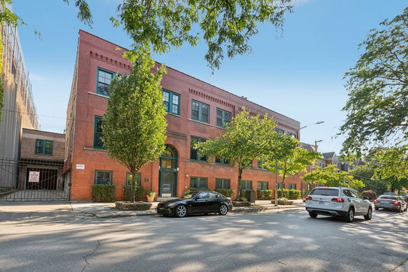 Front view of a three-story brick building with multiple windows.