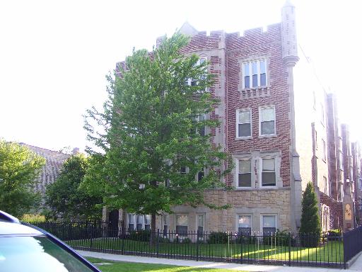 Front view of a multi-story brick building with decorative stone elements.