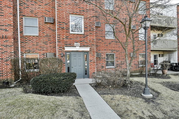 Front view of a brick apartment building with a gray door.