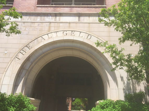 Front view of a building with a large arched entrance and brick facade.