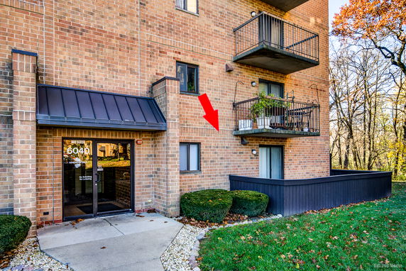 Front view of a multi-story brick building with balconies and a main entrance.