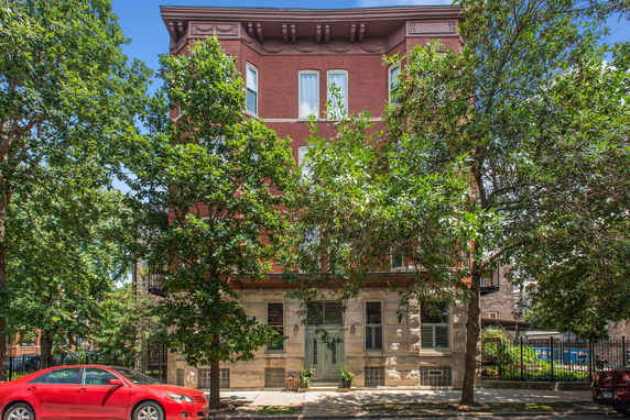 Front view of a three-story brick building with decorative architectural elements.