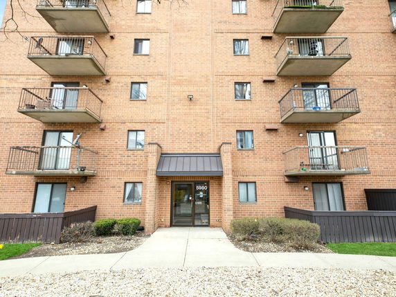 Front view of a multi-story brick building with balconies.