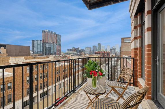 View from a balcony overlooking urban buildings and a city skyline.